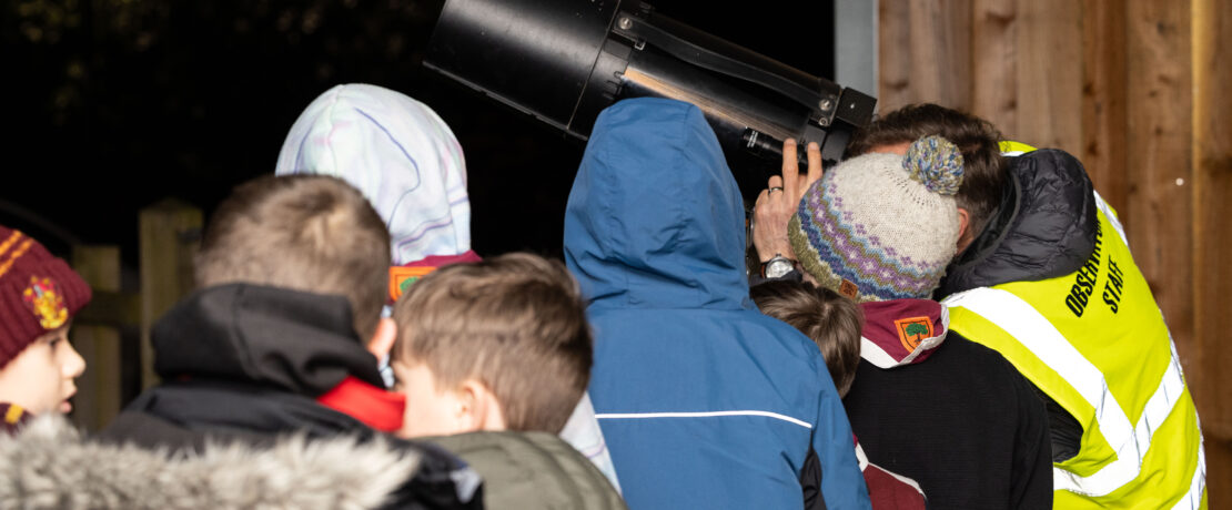 A group of people looking through a telescope